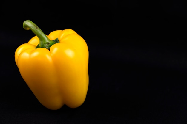 Bunte und saftige gelbe Paprika auf schwarzem Hintergrund