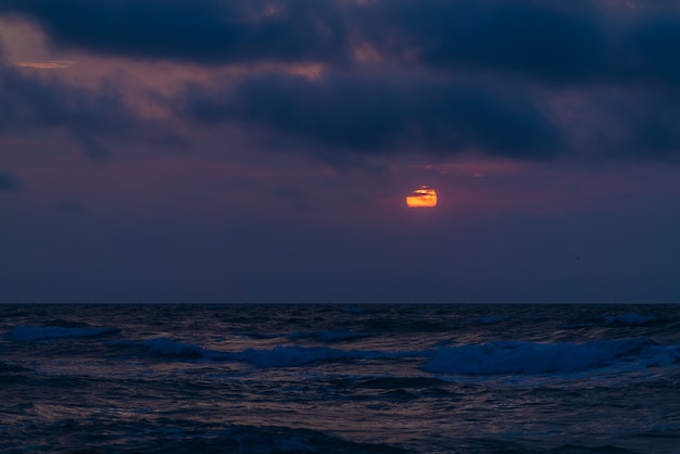 Bunter dramatischer Sonnenuntergang auf See