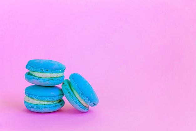 Bunter Einhornblauer Macaron oder Makronendessertkuchen der süßen Mandel lokalisiert auf trendigem rosa Pastellhintergrund.