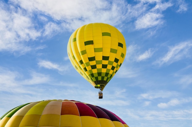 Bunter Heißluftballon, der über blauen Himmel fliegt