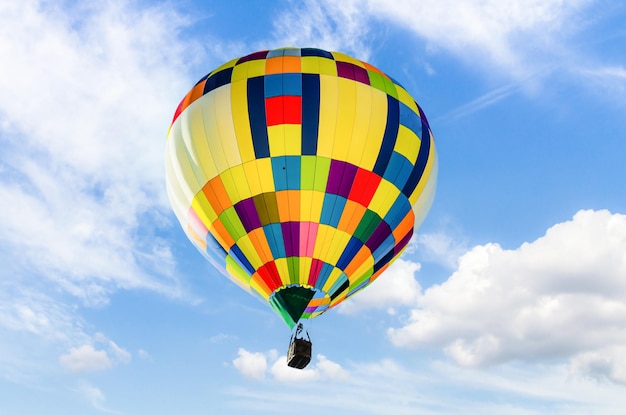 Bunter Heißluftballon, der über blauen Himmel fliegt