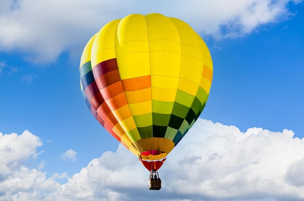 Bunter Heißluftballon, der über blauen Himmel fliegt.