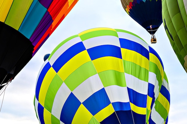 Bunter Heißluftballon, der über blauen Himmel mit weißen Wolken fliegt.