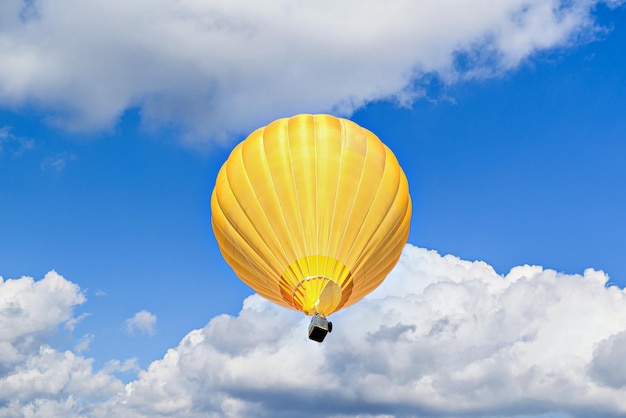 Bunter Heißluftballon, der über blauen Himmel mit weißen Wolken fliegt.