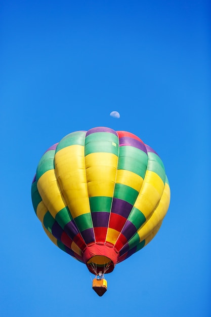 bunter Heißluftballon mit Mond im blauen Himmel