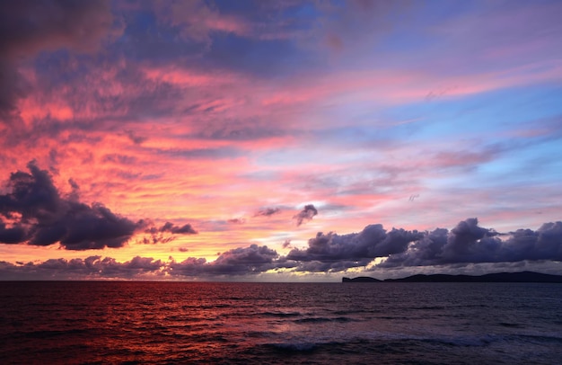 Bunter Himmel über Capo Caccia bei Sonnenuntergang Italien