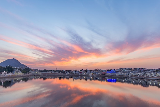 Bunter Himmel und Wolken über Pushkar, Rajasthan, Indien. Tempel, Gebäude und Farben, die über das Weihwasser des Sees bei Sonnenuntergang nachdenken.