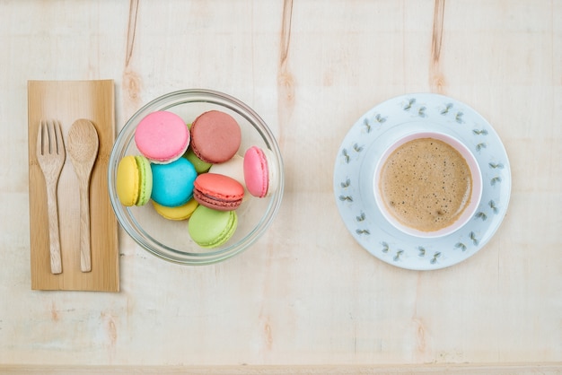 Bunter Pastellkuchen macaron mit Kaffeehintergrund von oben