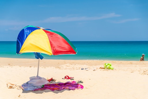 bunter Regenschirm auf tropischem Strand und Meer in der Paradiesinsel