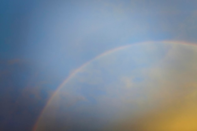Bunter runder Regenbogen gegen blauen Abendhimmel nach schwerem Gewitter