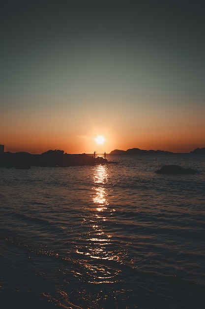 Bunter Sonnenuntergang mit zwei Fischern