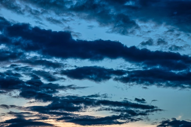 Bunter Sonnenunterganghimmel und -wolken, Bilddämmerungshintergrund. Abstrakte Naturhintergründe. Dramatische blaue und orangefarbene Wolken in der Dämmerung. Platz für Site kopieren