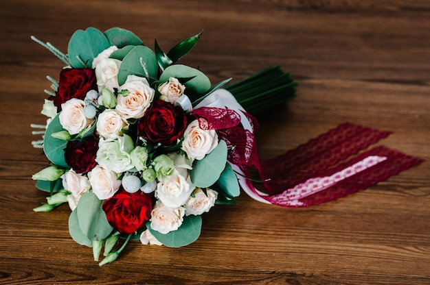 Bunter stilvoller Hochzeitsblumenstrauß von Blumen liegt auf dem braunen Hintergrund. Blumenstrauß der Braut.