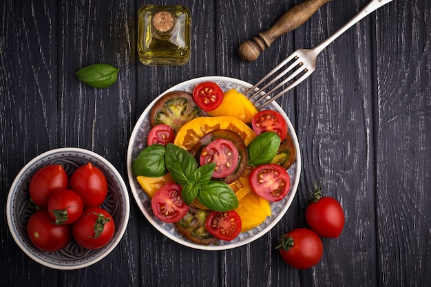 Bunter Tomatensalat im schwarzen Hintergrund. Selektiver Fokus