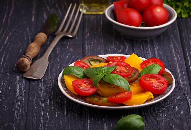 Bunter Tomatensalat im schwarzen Hintergrund