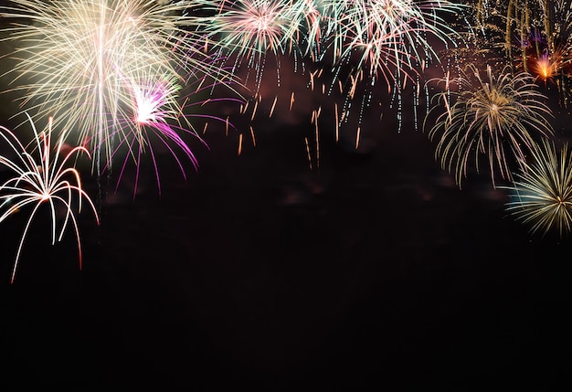 Buntes Feuerwerk auf dem schwarzen Himmelshintergrund mit Kopienraum für Text. Neujahrsfeier und Jubiläumskonzept