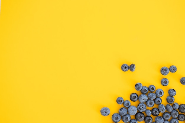 Buntes Fruchtmuster von Blaubeeren auf gelbem Hintergrund