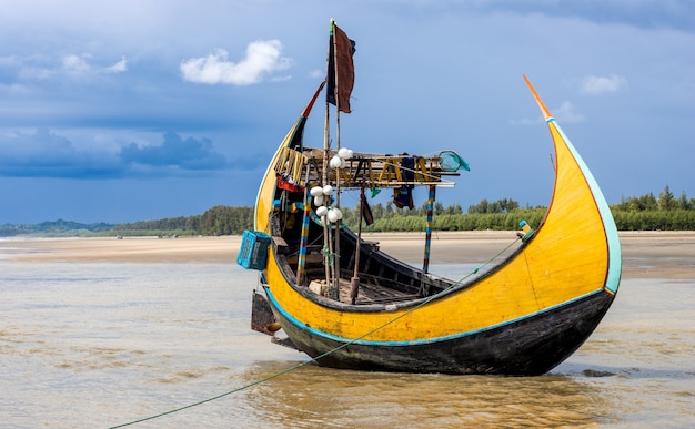 Buntes großes Fischerboot aus Holz, das an einem Meeresstrand geparkt ist