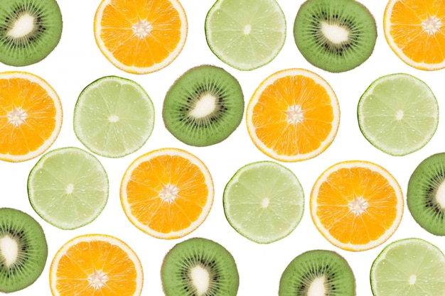 Buntes Muster der Kiwi, des Kalkes und der Orangen. Draufsicht der Zitrusfrüchte und der geschnittenen Kiwi.