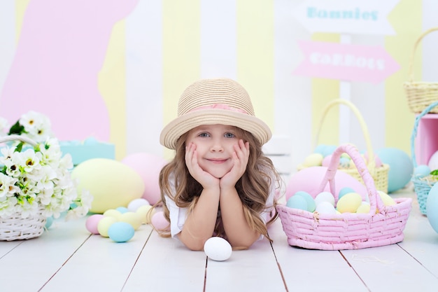 Buntes Osterdekor im Haus. Mädchen in der Nähe von Korb mit bemalten Eiern. kleines Mädchen jagt nach Ostereiern. Mädchen hat Korb mit gemalten Eiern. Kleiner Bauer. Frühlingsdekor. Ostern Interieur. Kinderzimmer