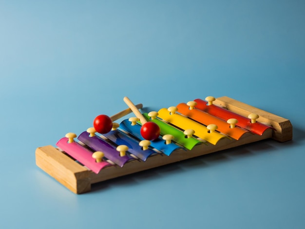 Buntes pädagogisches Xylophonspielzeug auf blauem Hintergrund mit Kopienraum. Kinderspielzeug und Musikinstrument.