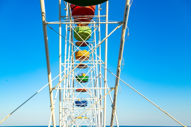 Buntes Riesenrad des Vergnügungsparks im blauen Himmel