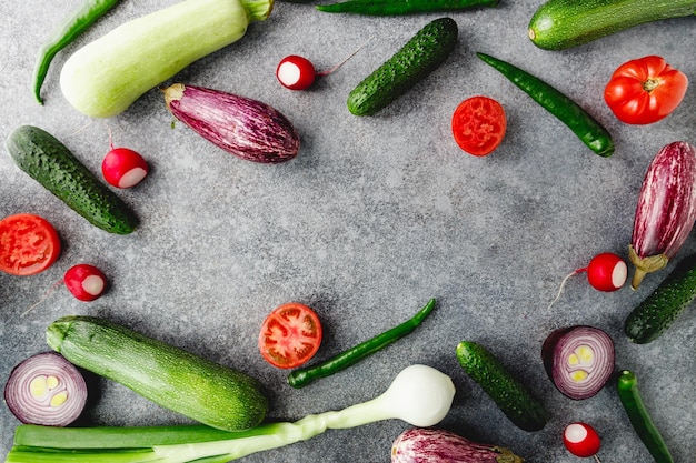 Buntes Sommermuster mit verschiedenen frischen Gemüsen auf grauem Hintergrund Flache Ansicht von oben