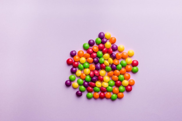 Buntes Süßigkeiten-Bonbon-Snack-Set. Süßer rosa Hintergrund. Ansicht von oben, flach