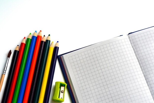 Buntstifte und Notebook isoliert auf weißem Hintergrund Schulmaterial
