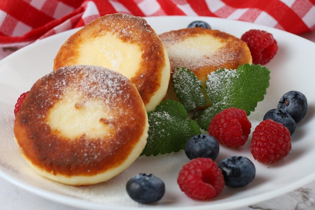 Buñuelo de cuajada con bayas en un plato Buñuelos de requesón