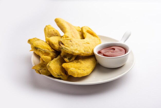 Buñuelo de plátano o pakora o kela pakodaÃƒÂ‚Ã‚Â o bajji crudos servidos con chutney. Merienda popular de Kerala, India o Indonesia. servido con té