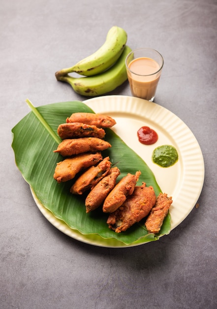 Buñuelo de plátano o pakora o kela pakodaÃƒÂ‚Ã‚Â o bajji crudos servidos con chutney. Merienda popular de Kerala, India o Indonesia. servido con té