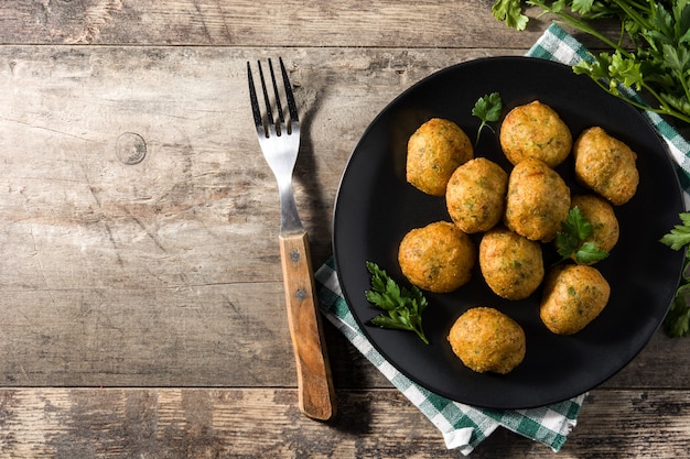 Buñuelos de bacalao tradicionales decorados con ajo y perejil