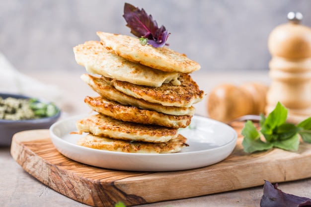 Buñuelos de calabacín vegetarianos o panqueques cubiertos con crema agria