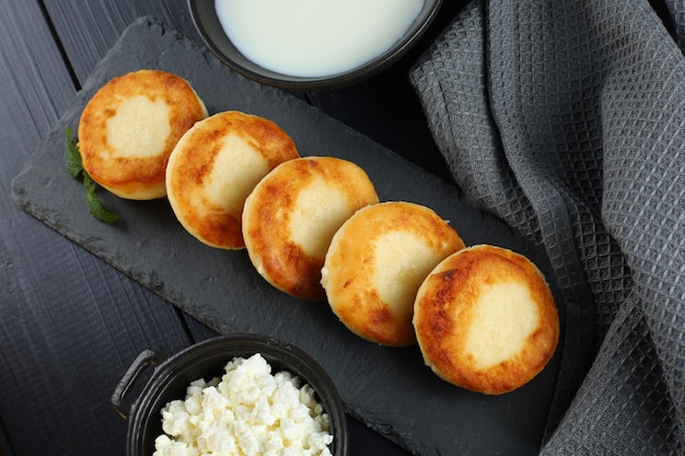Buñuelos de cuajada con leche y requesón Foto de comida en un tono oscuro