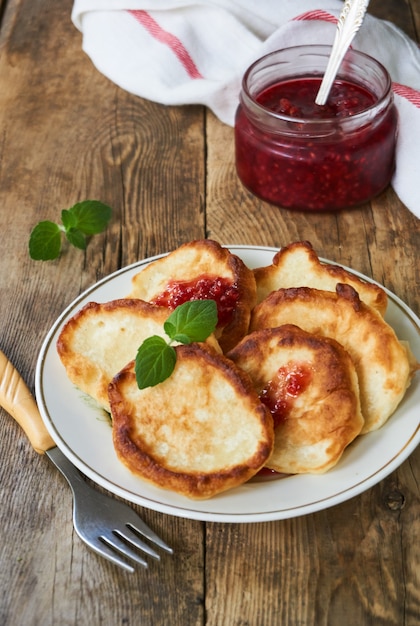 Buñuelos con mermelada de frambuesa en un plato blanco