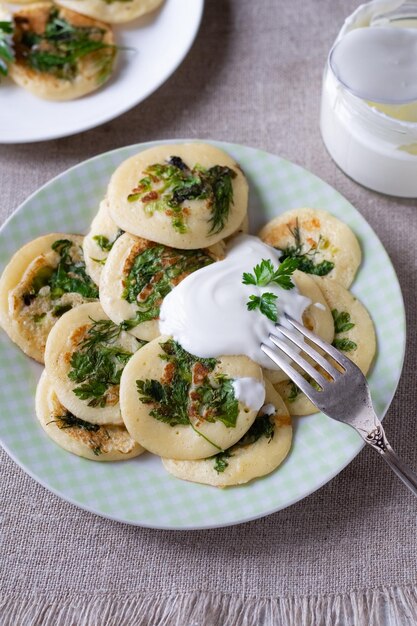 Foto buñuelos con perejil verde, lechuga, eneldo y crema agria