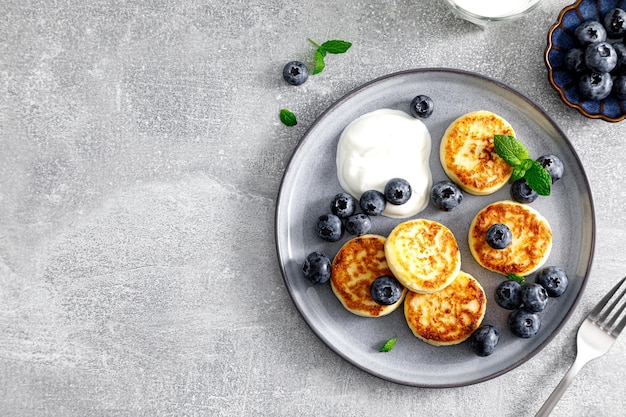 Buñuelos de requesón con arándanos frescos y yogur para el desayuno vista desde arriba