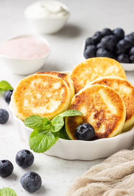 Buñuelos de requesón con arándanos, menta y salsa.