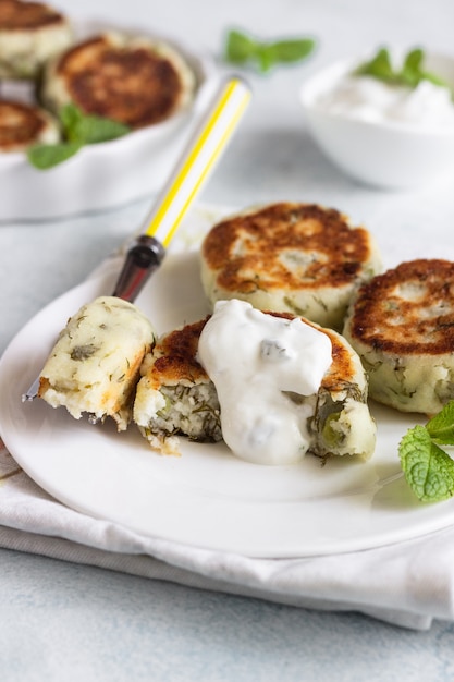 Buñuelos de requesón con guisantes verdes, eneldo, menta y salsa.