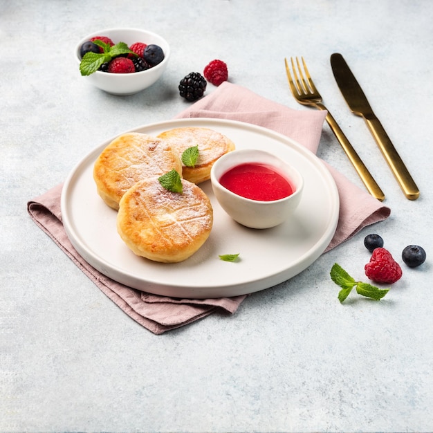 Buñuelos de requesón o Syrniki servidos con salsa y bayas vista superior comida rusa ucraniana