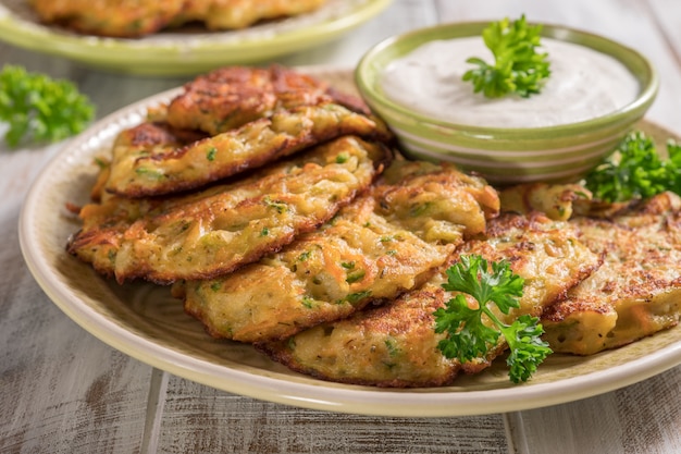 Buñuelos de vegetales con papa, zanahoria, calabacín servido con salsa Ranch.