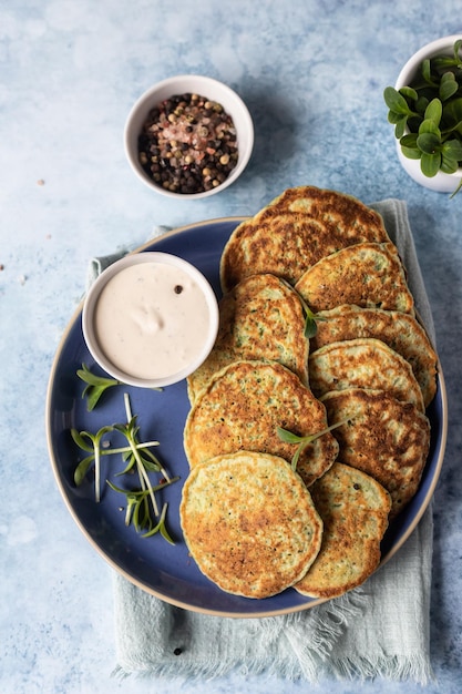 Buñuelos de verduras o tortitas de calabacín brócoli o espinacas con microgreen y dip