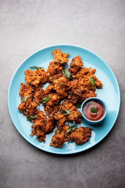 Buñuelos de zanahoria o Gajar ke pakore o pakode o bajji o bhaji, bocadillo indio servido en un plato con salsa de tomate