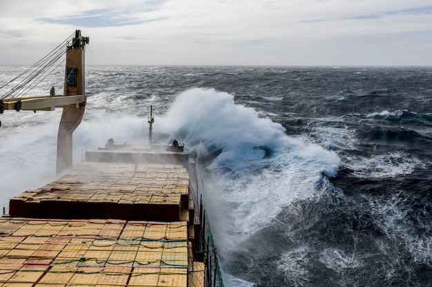 Buque de carga con carga en cubierta en mar tempestuoso Vista desde el puente de navegación Mar tempestuoso Mal tiempo Gale Mar embravecido