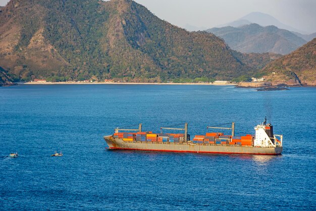 Foto buque de carga cargado de contenedores navegando en las aguas marinas de la bahía de guanabara en río de janeiro