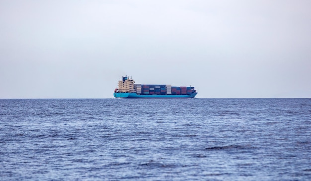 Buque de carga de contenedores cargado en el fondo del mar azul y tranquilo