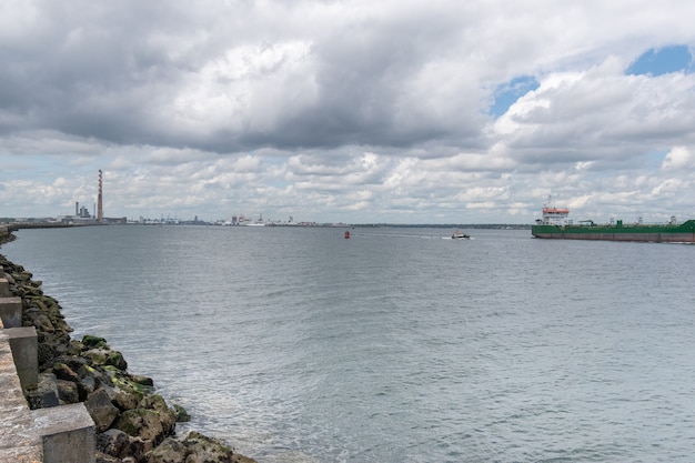 Buque de carga entrando en el puerto de Dublín en el faro de Poolbeg de irlandés ver.