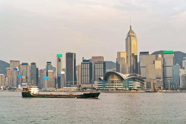 Buque de carga seca en el puerto de Victoria en Hong Kong al atardecer. Vista desde Kowloon en la isla de Hong Kong.