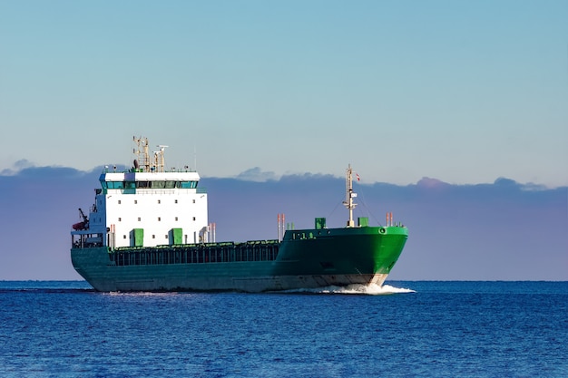 Buque de carga verde moviéndose en aguas tranquilas del mar Báltico